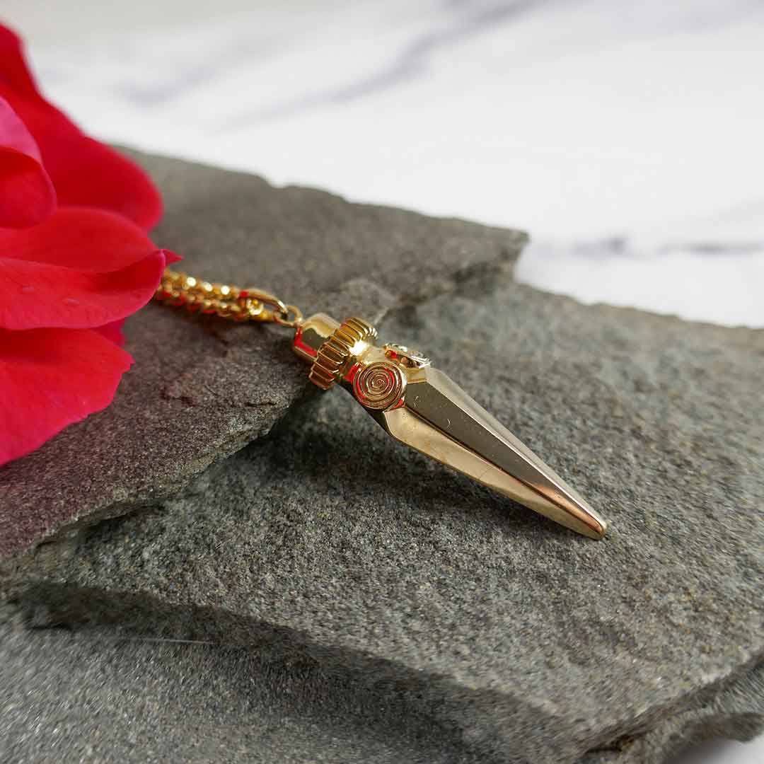 gold pendant inspired in ancient female deities on a rock